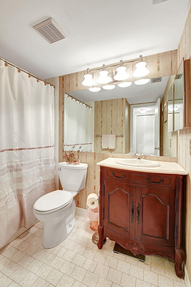 bathroom with wooden walls, toilet, tile flooring, and vanity