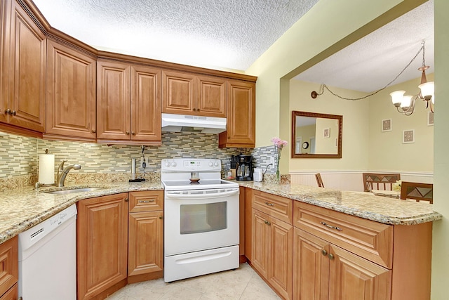 kitchen featuring a textured ceiling, sink, white appliances, tasteful backsplash, and light stone countertops