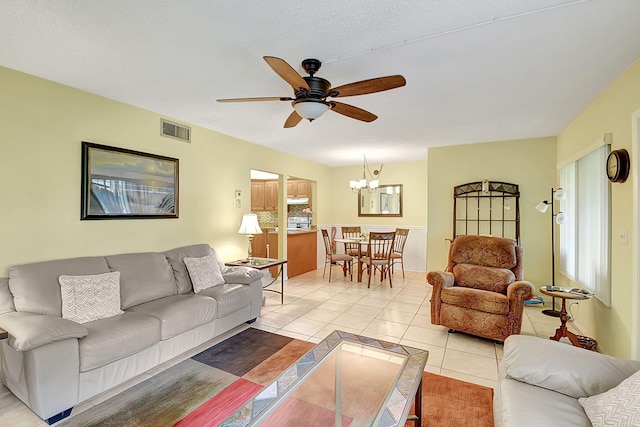 living room featuring ceiling fan with notable chandelier, a wealth of natural light, and light tile flooring