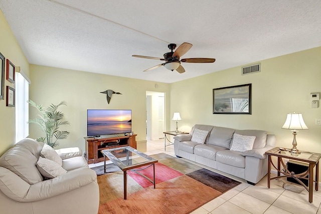 tiled living room featuring ceiling fan and a textured ceiling