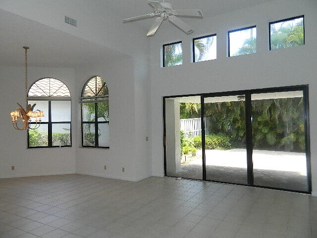 spare room with ceiling fan, light tile patterned floors, and a wealth of natural light