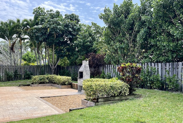 view of yard featuring a patio and an outdoor fireplace