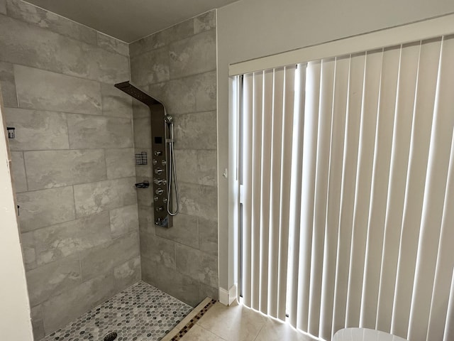 bathroom featuring a tile shower, radiator, and tile patterned flooring