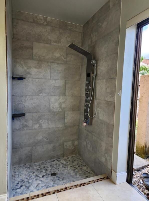 bathroom with tile patterned floors and tiled shower