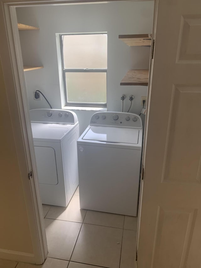 laundry room with washer and dryer and light tile patterned flooring