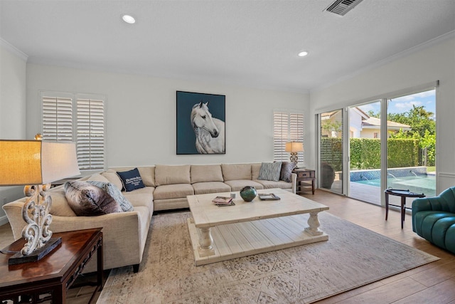 living room featuring crown molding and light hardwood / wood-style flooring