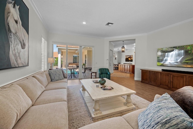 living room with crown molding and light hardwood / wood-style floors