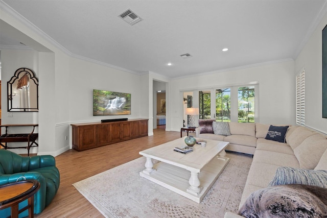 living room with light hardwood / wood-style flooring and ornamental molding