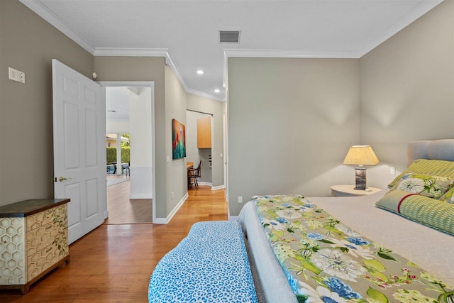 bedroom with crown molding and light hardwood / wood-style floors