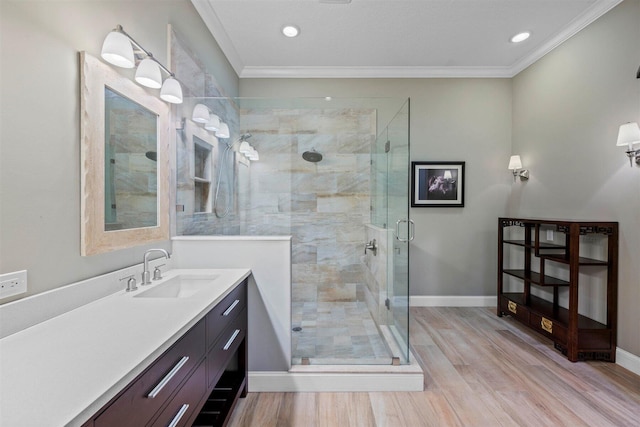 bathroom with walk in shower, crown molding, large vanity, and hardwood / wood-style flooring