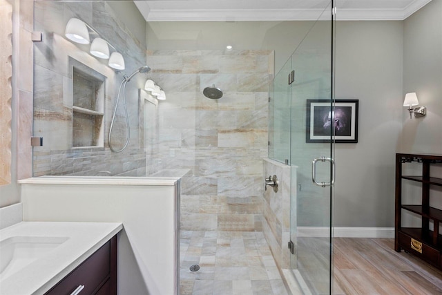 bathroom with vanity, hardwood / wood-style floors, crown molding, and a shower with door