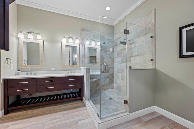 bathroom with hardwood / wood-style floors, double vanity, ornamental molding, and a shower with shower door