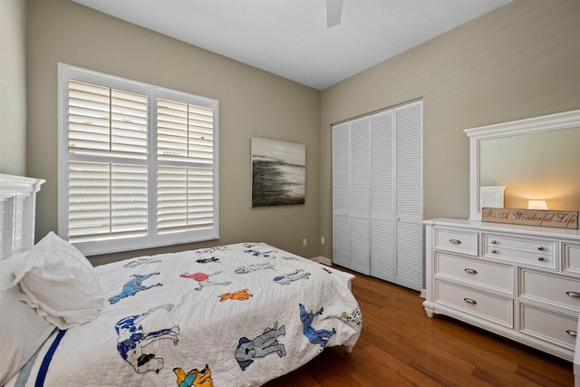 bedroom with a closet, ceiling fan, and dark hardwood / wood-style flooring