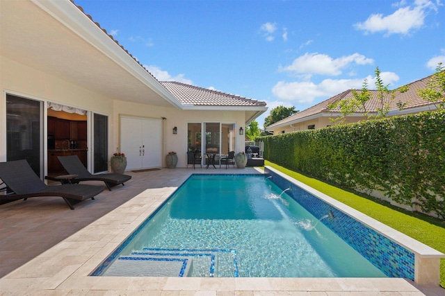 view of pool with pool water feature and a patio