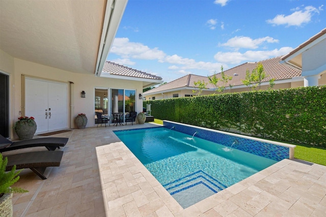 view of pool with pool water feature and a patio area