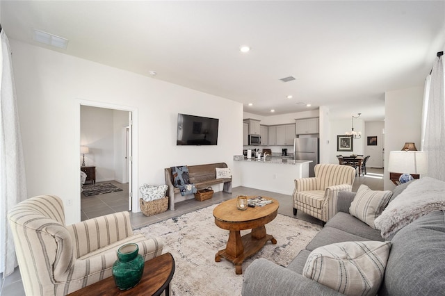 living room featuring light tile floors and a chandelier