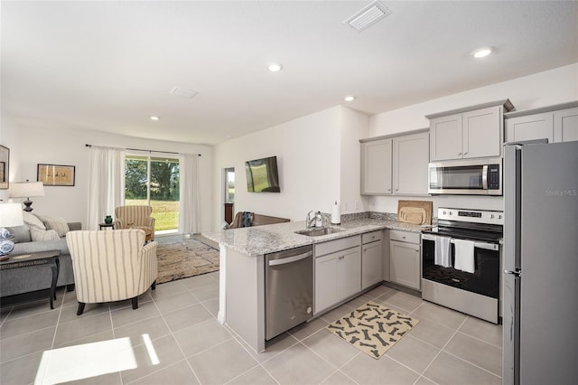 kitchen featuring light tile flooring, stainless steel appliances, kitchen peninsula, and gray cabinets