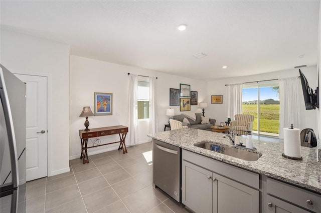 kitchen with light tile flooring, appliances with stainless steel finishes, sink, gray cabinetry, and light stone counters