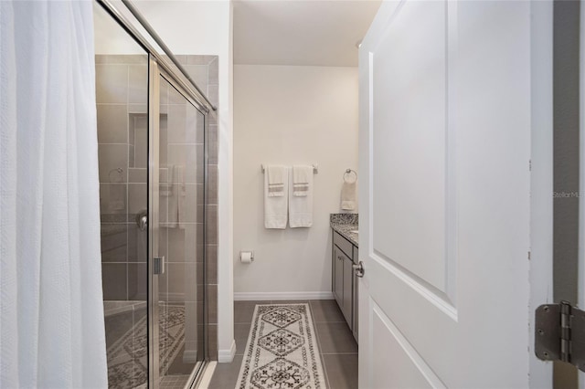 bathroom with an enclosed shower, vanity, and tile flooring