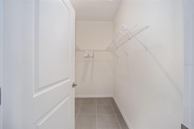 walk in closet featuring light tile floors