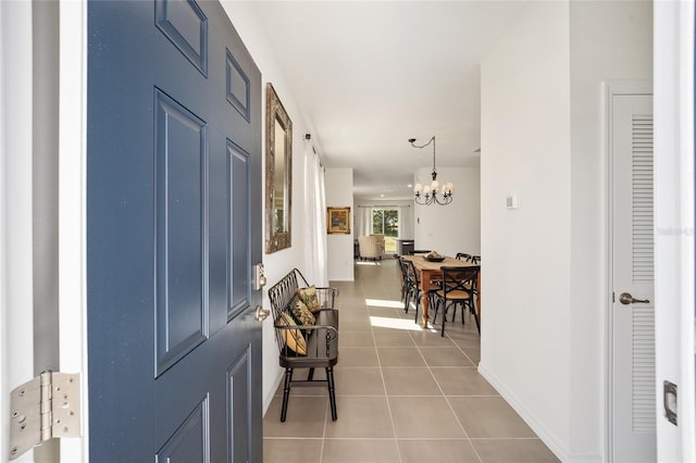 tiled foyer entrance featuring a notable chandelier