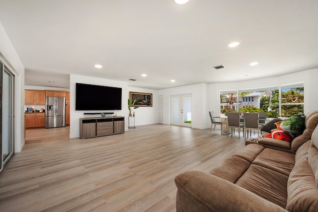 living room with light hardwood / wood-style flooring and french doors