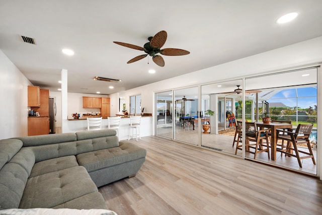 living room featuring light wood-type flooring and ceiling fan