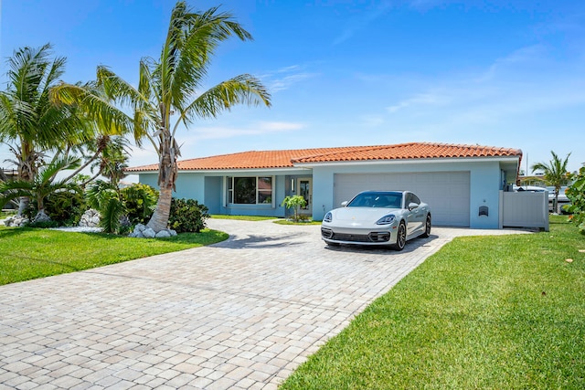 single story home featuring a garage and a front lawn