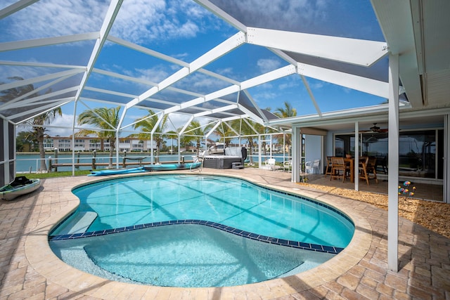 view of pool with a patio area, ceiling fan, and glass enclosure