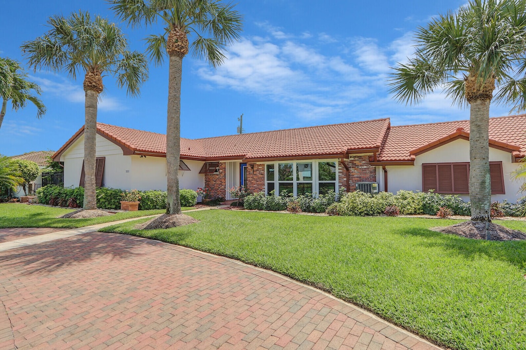 ranch-style house featuring central AC and a front lawn