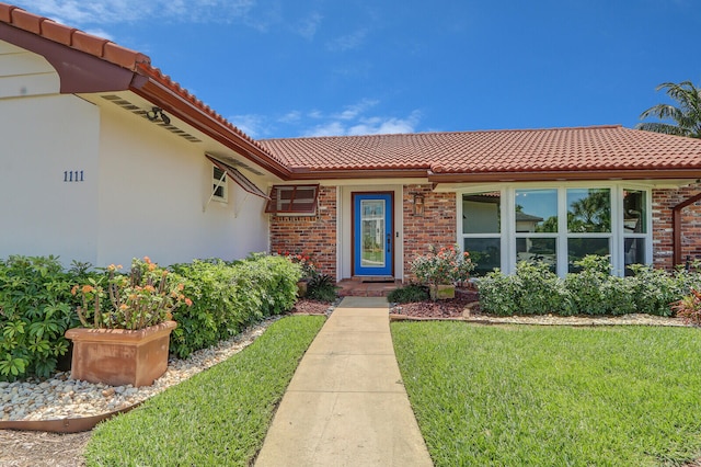 entrance to property with a lawn