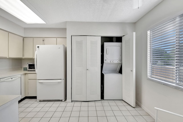 7185 Huntington Ln Unit 301, Delray Beach, FL 33446 - kitchen with white appliances, stacked washer / dryer, light countertops, and light tile patterned floors