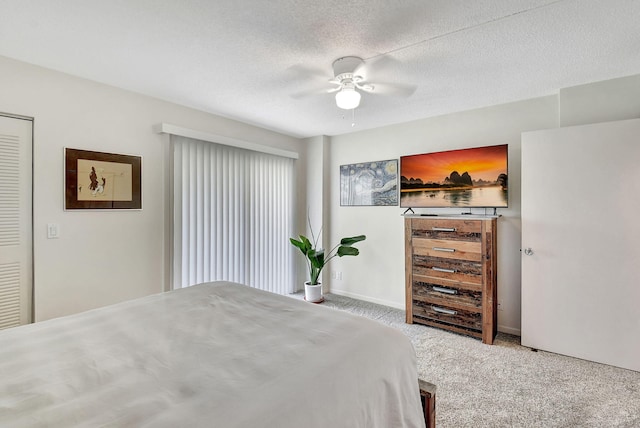 bedroom with ceiling fan, carpet, and a textured ceiling