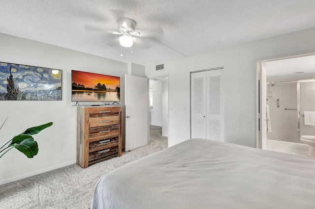 carpeted bedroom featuring ceiling fan, a closet, ensuite bathroom, and a textured ceiling