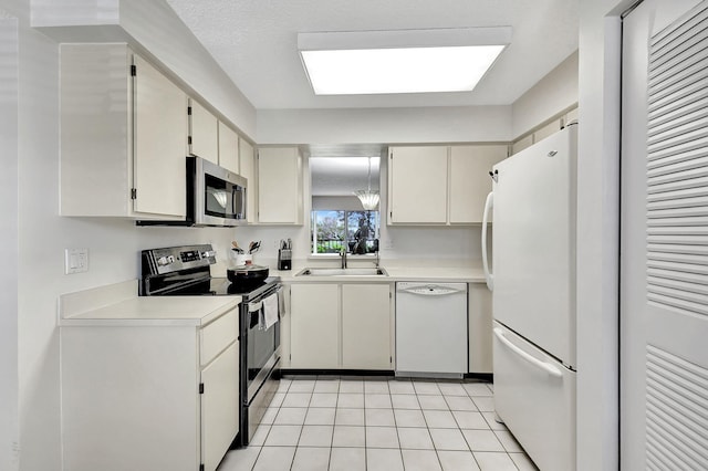 kitchen with light tile patterned flooring, sink, and appliances with stainless steel finishes