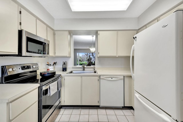 kitchen featuring sink, light tile patterned floors, an inviting chandelier, and appliances with stainless steel finishes