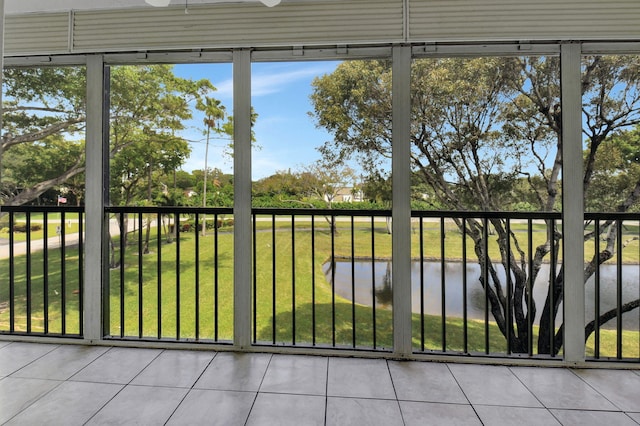 unfurnished sunroom featuring ceiling fan, a healthy amount of sunlight, and a water view