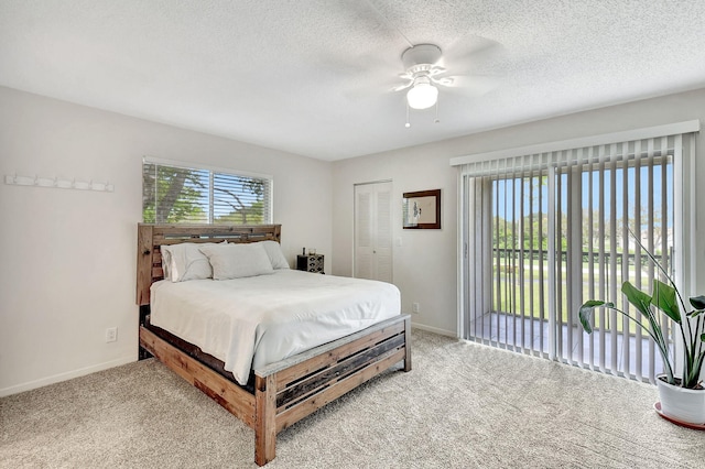 carpeted bedroom featuring access to outside, a textured ceiling, a closet, and ceiling fan