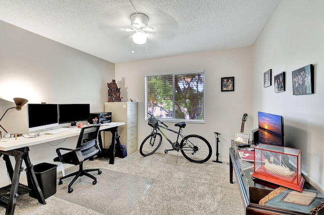 home office featuring ceiling fan, carpet floors, and a textured ceiling