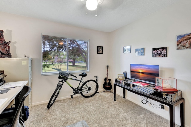 carpeted office featuring ceiling fan and a textured ceiling