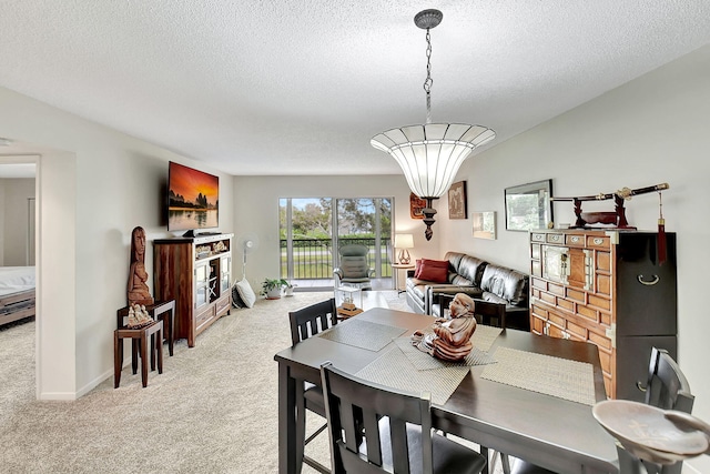 carpeted dining room featuring a textured ceiling