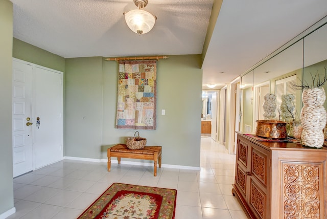 foyer entrance with a textured ceiling and light tile flooring