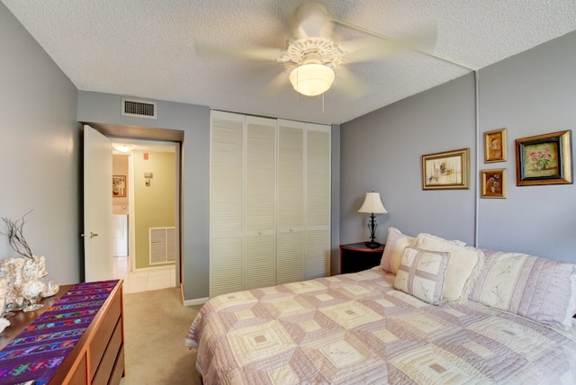 bedroom with light colored carpet, ceiling fan, a textured ceiling, and a closet