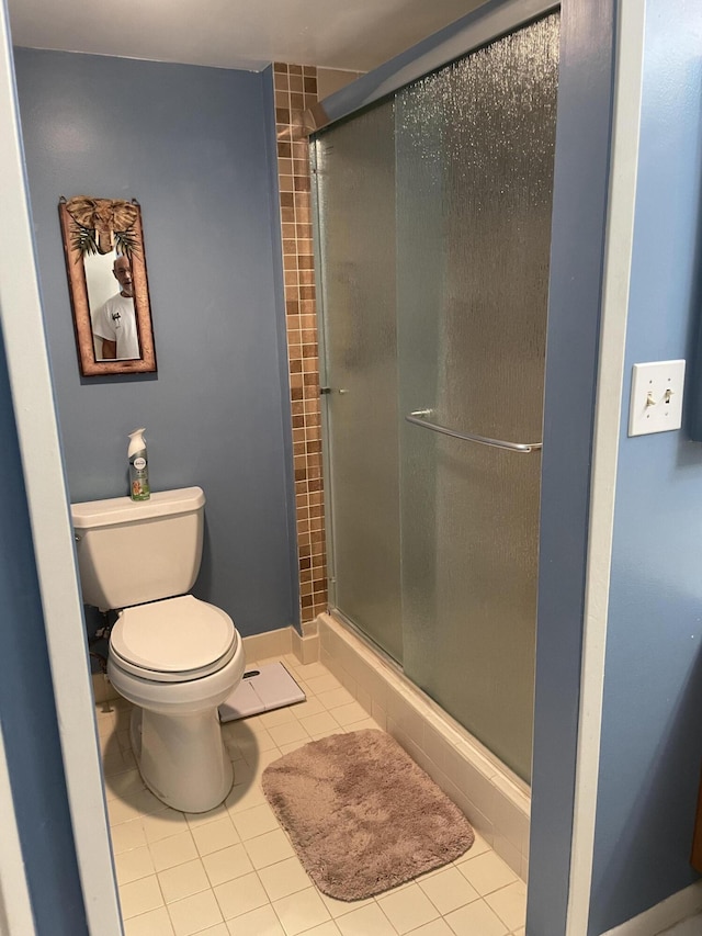 bathroom featuring tile floors, an enclosed shower, and toilet