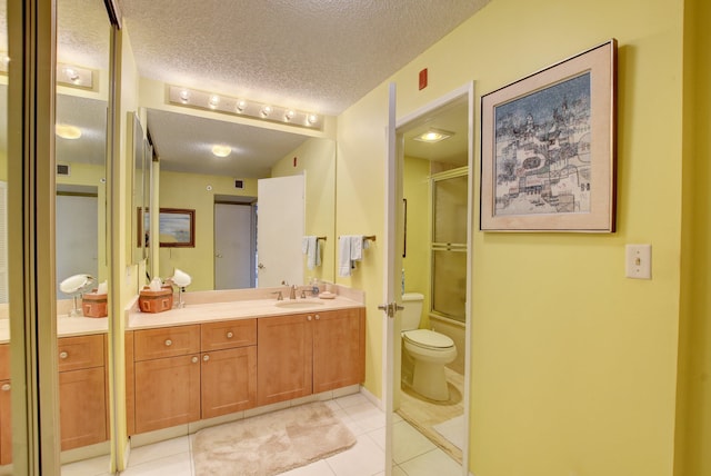 bathroom with a textured ceiling, vanity, tile floors, and toilet