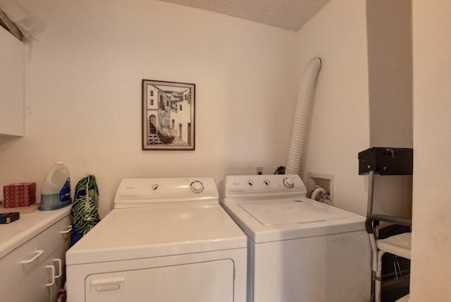 laundry area featuring washing machine and dryer, cabinets, hookup for a washing machine, and a textured ceiling