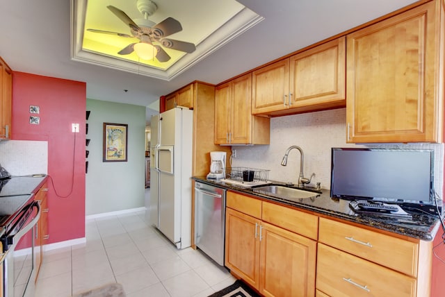 kitchen featuring ceiling fan, a tray ceiling, dark stone counters, and white refrigerator with ice dispenser