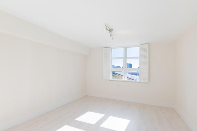 unfurnished room featuring light hardwood / wood-style floors and track lighting