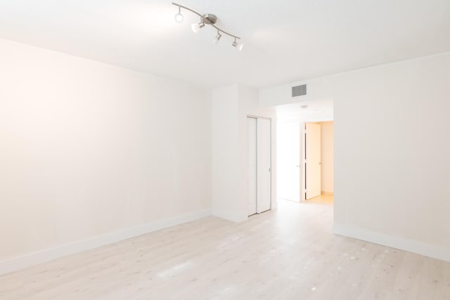 unfurnished room featuring light wood-type flooring and track lighting