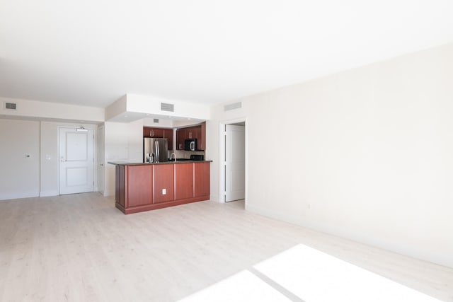 unfurnished living room featuring light hardwood / wood-style flooring and sink